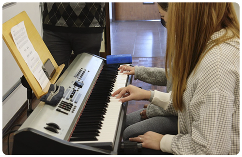 Alunas tocando teclado na Escola de Música da UCS