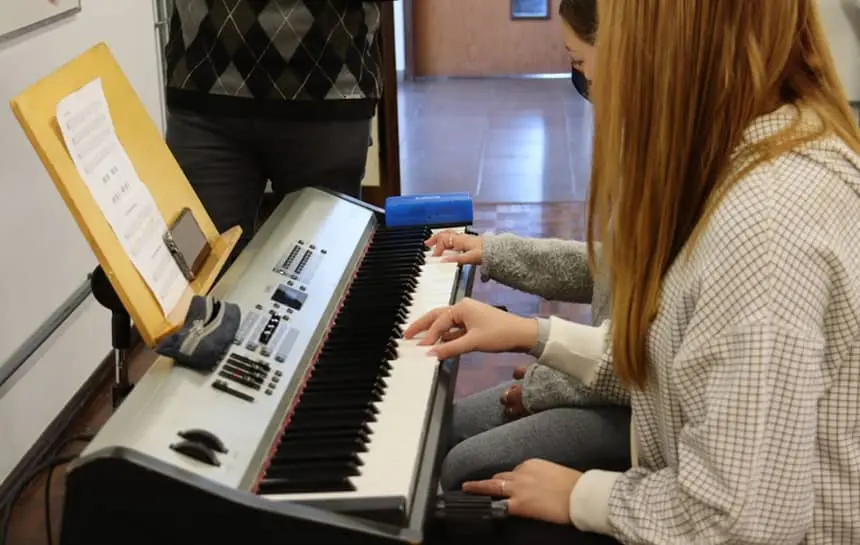 Alunas tocando teclado na Escola de Música da UCS